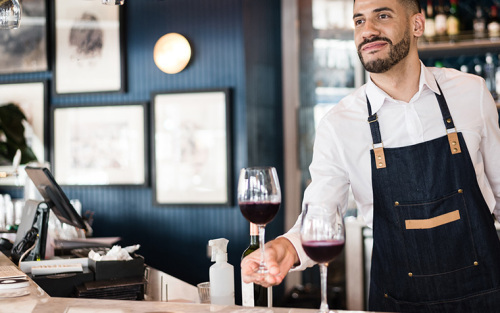 Bar tender serving a glass of wine