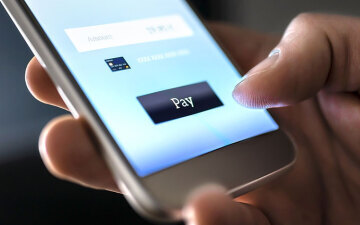 close up of a hand completing an online payment on a mobile phone