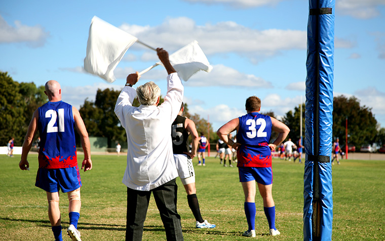 Goal umpire shows a goal has just been kicked