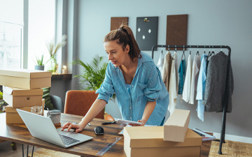 Women, owener of small business packing product in boxes