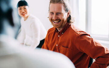 Smiling man in an office talking to someone